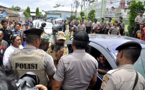 Papuan pro-independence activist Filep Karma (C) asks police for a permit to hold a convoy with his supporters after being released from prison in Abepura, Papua province, on November 19, 2015.