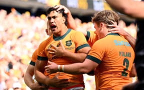 Joseph-Aukuso Suaalii of Australia celebrates with teammates after scoring a try.
