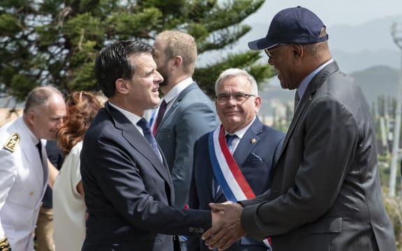 France's Minister of Overseas Manuel Valls (front L) greets the President of the Government of New Caledonia Alcide Ponga (R) as Senator Georges Naturel (C) looks on during his arrival for a military honours ceremony at the Croix de Lorraine in Noumea, France's Pacific territory of New Caledonia, on February 22, 2025. (Photo by Delphine MAYEUR / AFP)