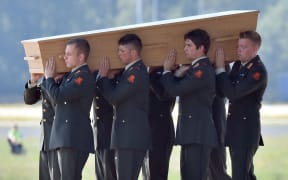 The coffins were brought from the plane by members of the military.