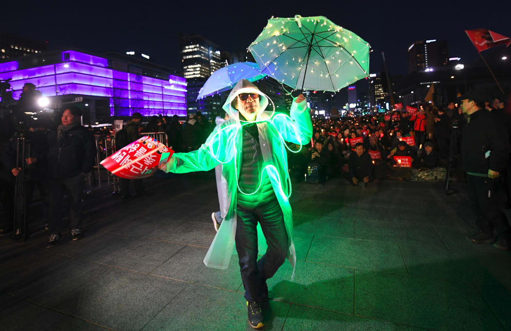 South Korean demonstrators wearing illuminated costumes take part in a candlelit rally demanding arrest of the impeached-president Park Geun-Hye in Seoul