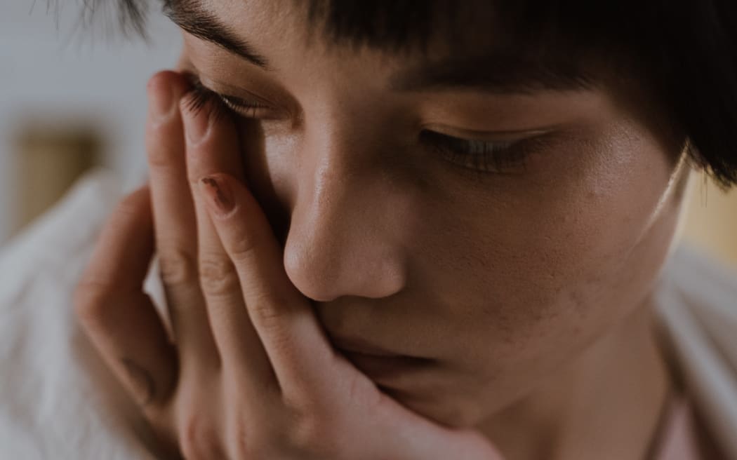 woman with hand on face