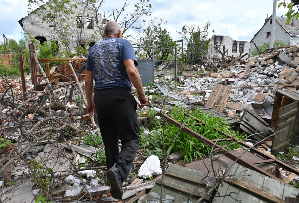 A local resident walks among debris in a yard of his destroyed house in the village of Mala Rogan, east of Kharkiv, on May 15, 2022, amid Russian invasion of Ukraine.