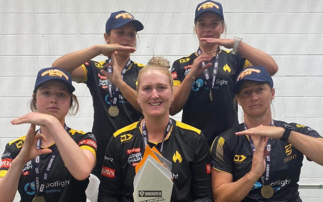 The five Tawa College alumni after the Welllington Blaze won the domestic T20 final in February 2022, making the 'T' for Tawa hand signal. Melie (left) and Jess Kerr (back row). From left to right (front row) Georgia Plimmer, Rebecca Burns and Sophie Devine.