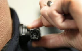 WEST VALLEY CITY, UT - MARCH 2: A West Valley City police officer shows off a newly-deployed body camera attached to his shirt collar on March 2, 2015 in West Valley City, Utah. West Valley City Police Department has issued 190 Taser Axon Flex body cameras for all it's sworn officers to wear starting today.   George Frey/Getty Images/AFP (Photo by GEORGE FREY / GETTY IMAGES NORTH AMERICA / Getty Images via AFP)
