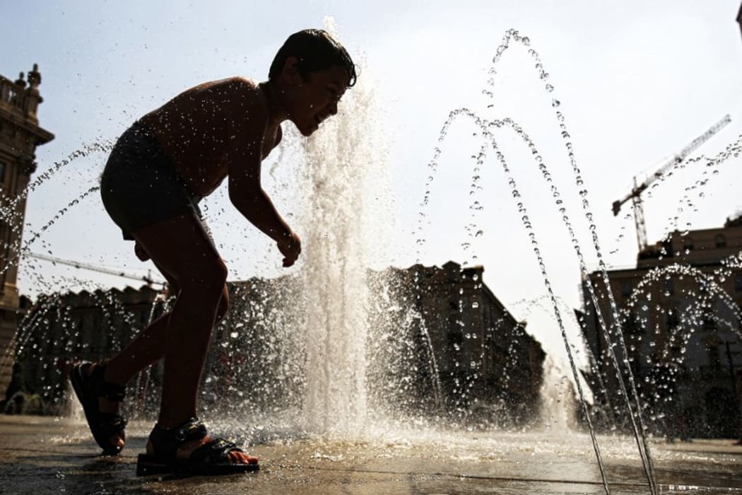 A young child refreshes himself with the waters of a fountain at Piazza Castello in Turin as they seek relief during a heatwave that continues to grip southern Europe.