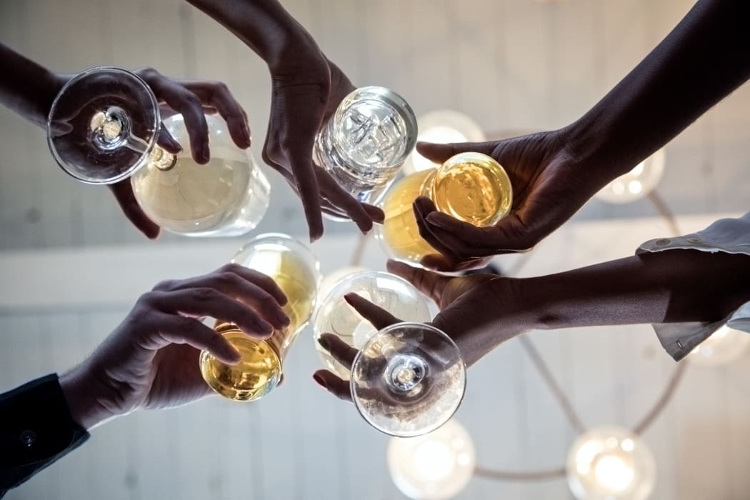 Group of friends making a toast, upward view of hands holding glasses (Photo by Gary John Norman / Connect Images / Connect Images via AFP)