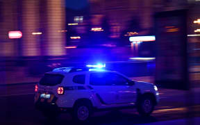 A police car drives on a street in central Kyiv early on February 24, 2022