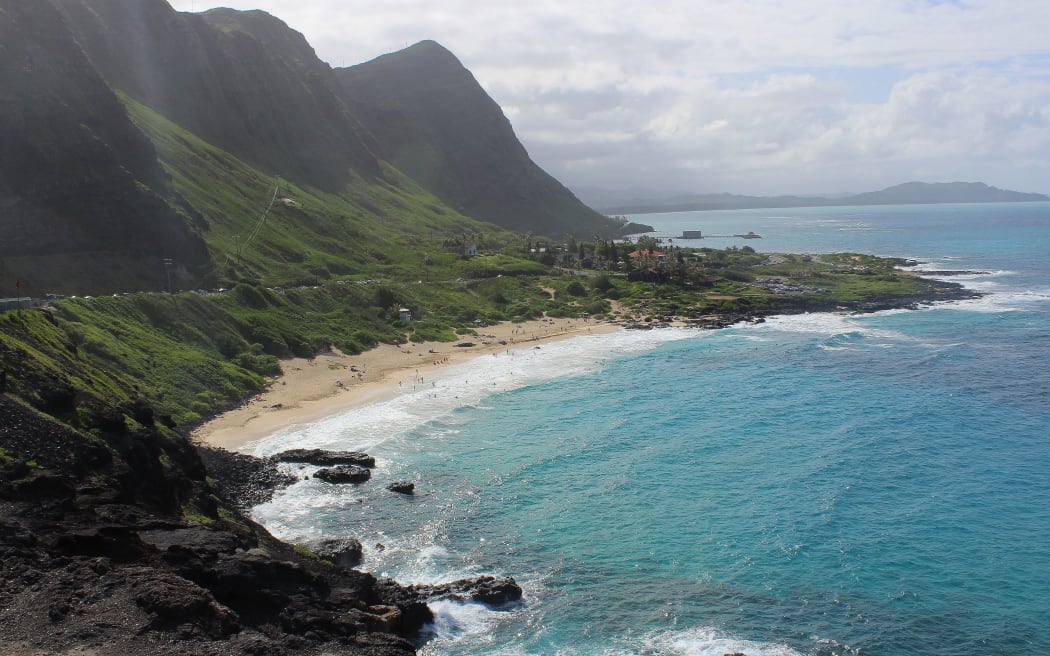 Steep hills drop down to the sea and a beach