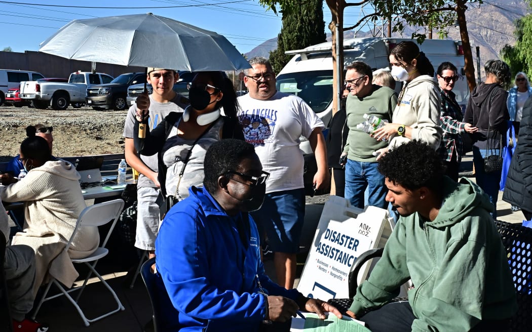 People wait to meet with FEMA officials on January 14, 2025 in Pasadena, California, where a FEMA Disaster Recovery Center opened today to help homeowners, renters, businesses and non-profits with their economic recovery. Hot, powerful winds on January 14 threatened to rekindle and whip up major fires that have devastated the hills and suburbs of Los Angeles, killing at last 24 people and changing the face of America's second biggest city forever. (Photo by Frederic J. BROWN / AFP)