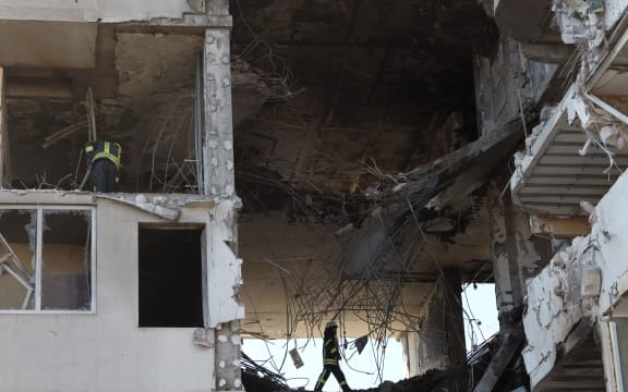 Rescuers clear debris in a damaged building in Odessa, southern Ukraine on April 24, 2022, which was reportedly hit by missile strike.