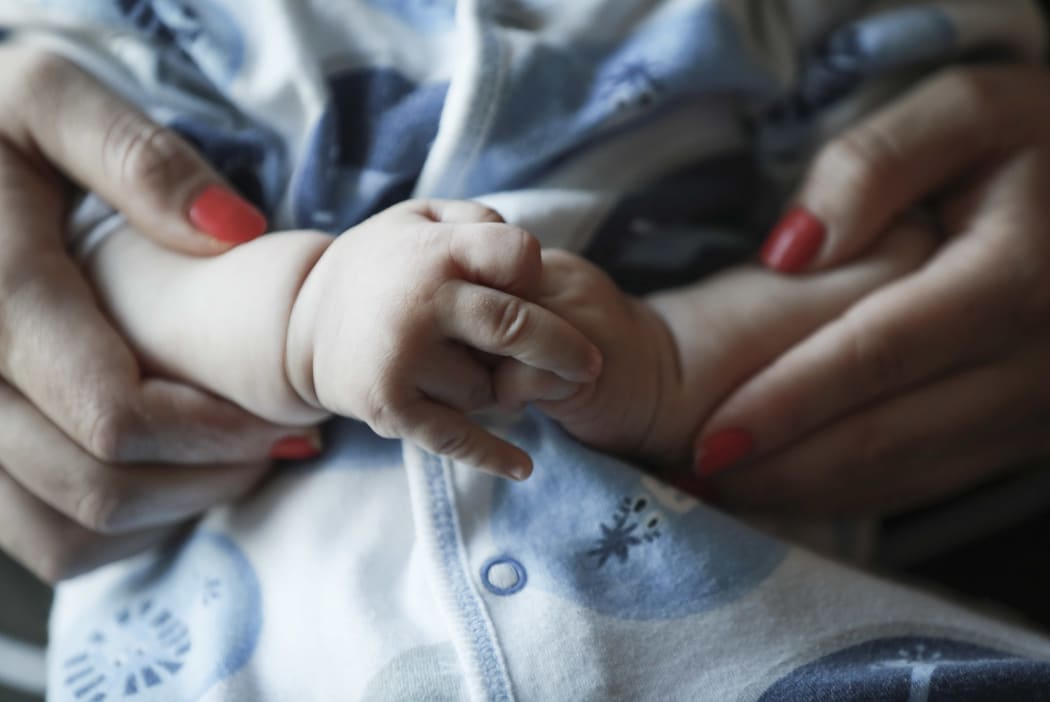 Hands of baby and mother