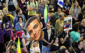 File photo. A demonstrator holds a sign showing the face of Israeli-US hostage Edan Alexander (C) during a protest calling for action to release the remaining hostages held captive in Gaza since the 7 October 2023 attacks by Palestinian militants, outside the Israeli Defence Ministry headquarters in Tel Aviv on 15 March 2025.