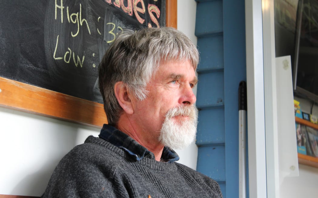 Man with beard sit outside camp office