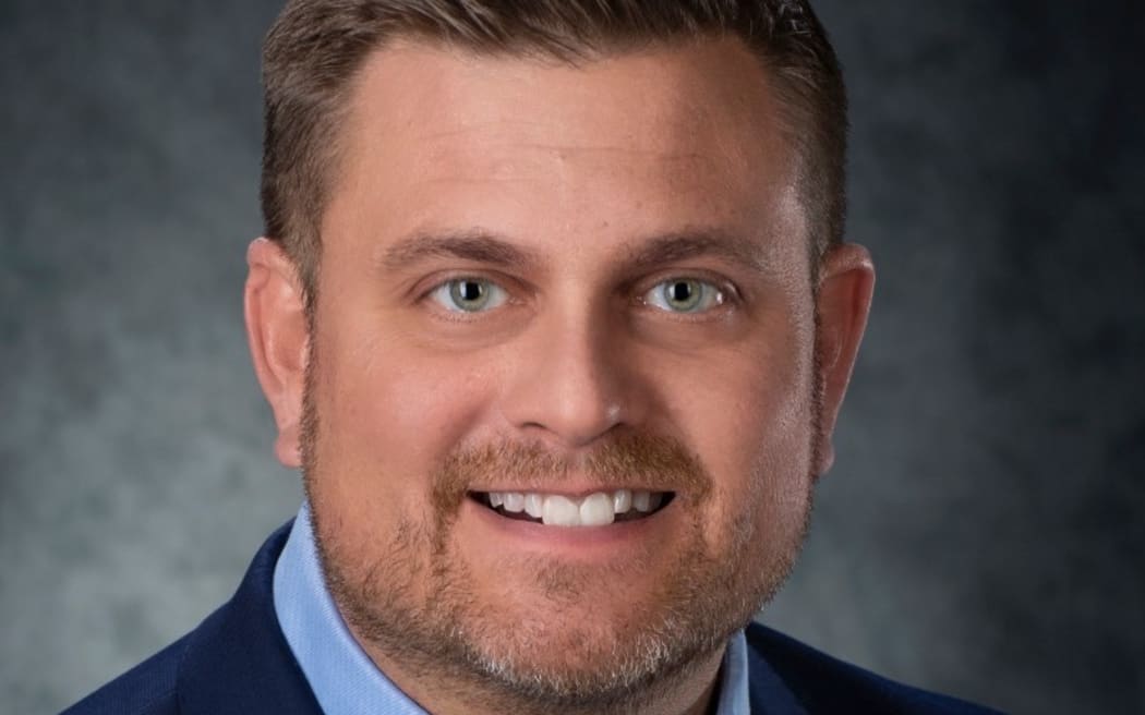 A headshot image of UnitedHealthcare CEO Brian Thompson. He is smiling and wearing a suit.
