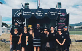 Food truck operators Karli Mitchell (centre right) and her partner Rutger Richter (centre left) have had to cancel travel plans due to Covid killing their income, and just want a refund they were promised on their travel.