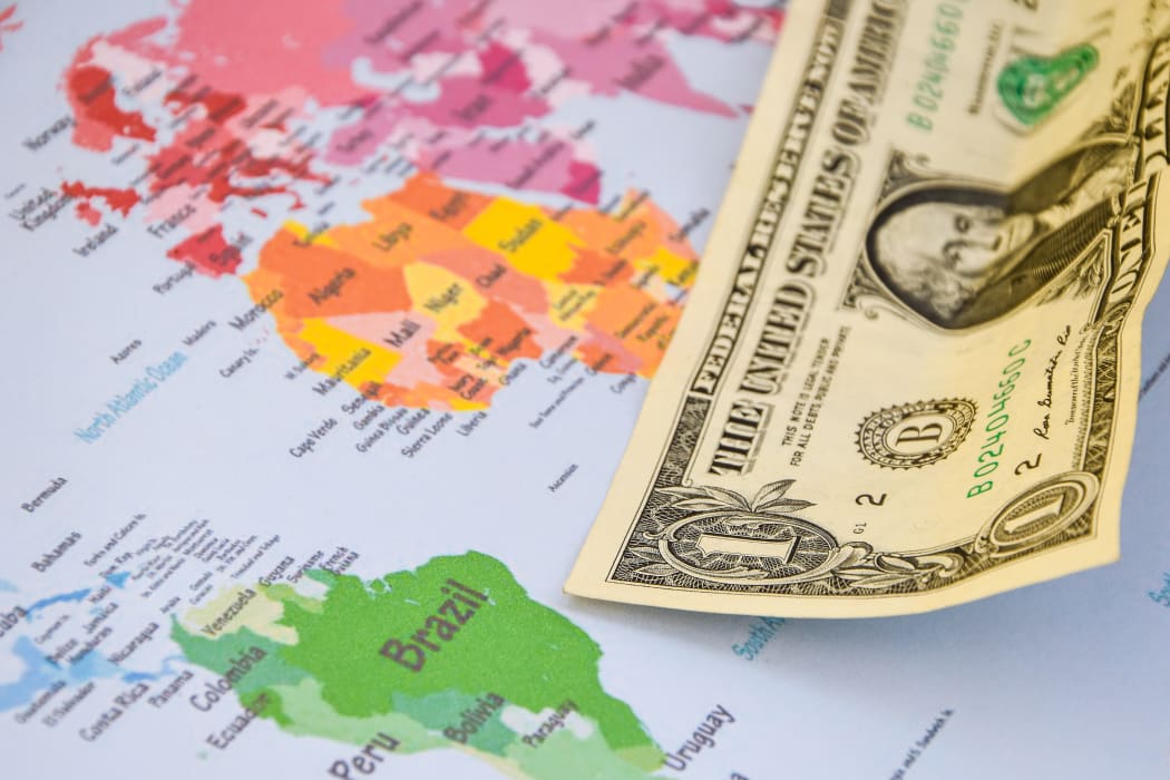 US dollar banknotes on globe world map, American investment and trading, concept of american policy and influence