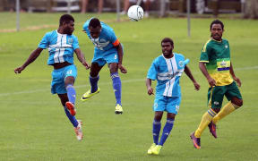 Malampa Revivors duo Marcelin Piloe and John Alick try to clear the ball against Lae City Dwellers.