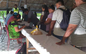 Voters check in before heading to the booths to their right at the Tangintebu Theological College Maneaba