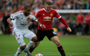 Wayne Rooney of Manchester United is forced off the ball by Ashley Williams of Swansea City in August 2015.