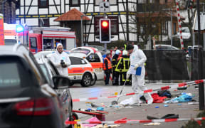 Police officers close to the site where a car drove into a carnival procession in Volkmarsen.