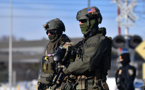 Federal law enforcement agents confront anti-US Immigration and Customs Enforcement (ICE) protesters outside the Bishop Henry Whipple Federal Building during a demonstration over the fatal shooting of Renee Good by an ICE agent in Minneapolis, Minnesota, on January 9, 2026. A US Immigration and Customs Enforcement (ICE) agent shot and killed an American woman on the streets of Minneapolis January 7, leading to huge protests and outrage from local leaders who rejected White House claims she was a domestic terrorist. The woman, identified in local media as 37-year-old Renee Nicole Good, was hit at point blank range as she apparently tried to drive away from agents who were crowding around her car, which they said was blocking their way. (Photo by Octavio JONES / AFP)