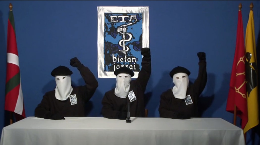 In this file photo grabbed on Gara.net on October 20, 2011 three ETA militants dressed in black shirts with white hoods over theIR heads and black berets making a declaration in an undisclosed location.