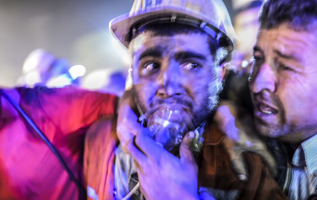 A miner is reunited with his father after emerging from the collapsed mine.