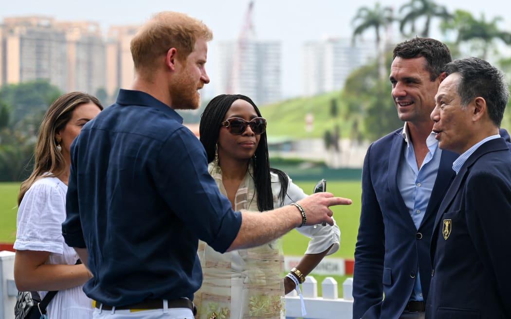 Britain's Prince Harry (2nd L) speaks with Sophie Chandauka (C), chair of the Sentebale board, and Dan Carter (2nd R), former All Blacks rugby player and current ISPS Handa ambassador, at the Sentebale ISPS Handa Polo Cup in Singapore on August 12, 2023. (Photo by Roslan RAHMAN / AFP)