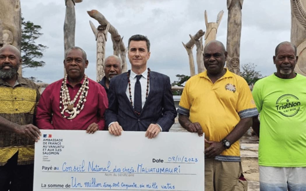 French ambassador to Vanuatu Jean-Baptiste Jeangène Vilmer hands over cheque towards rebuilding of Vanuatu’s council of chiefs Malvatumauri on 8 November 2023.