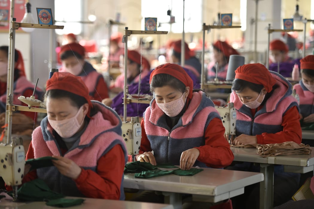 Workers of Songyo Knitwear Factory in Pyongyang produce masks for protection against the coronavirus.