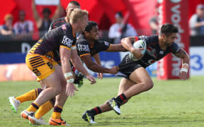 Warriors player Shaun Johnson is grabbed by the Broncos