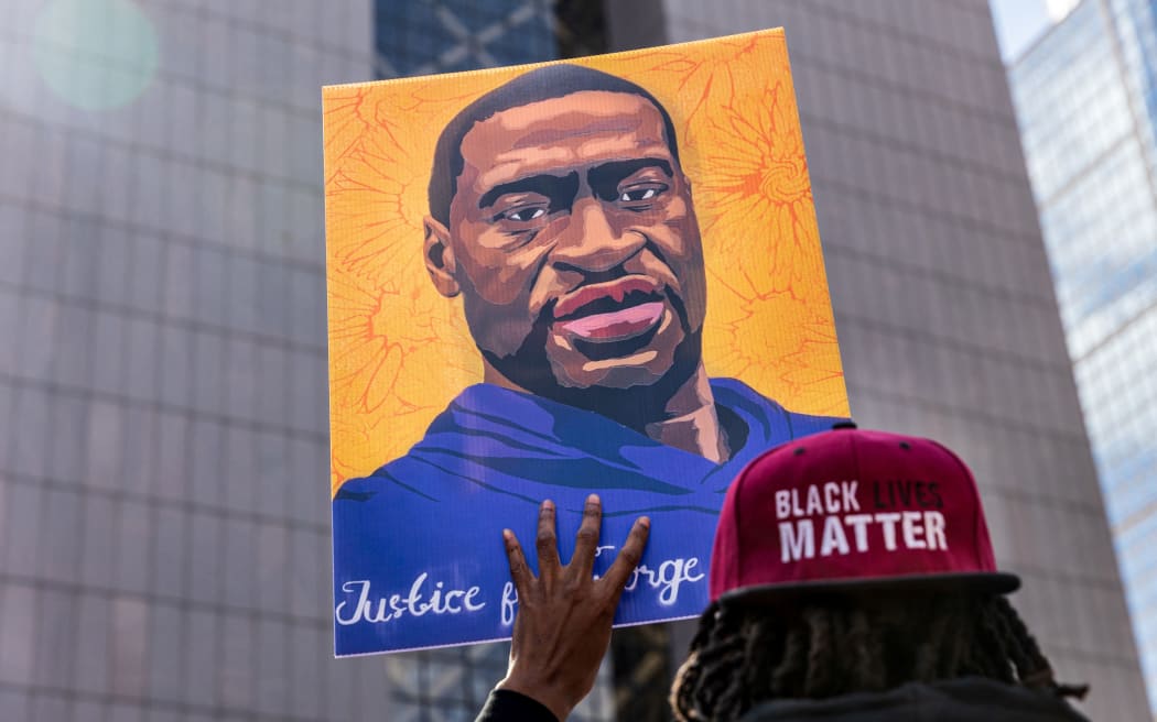 (FILES) In this file photo demonstrators hold signs honouring George Floyd and other victims of racism as they gather during a protest outside Hennepin County Government Center on March 28, 2021 in Minneapolis, Minnesota.