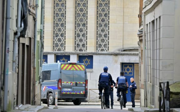 Police patrol by an entrance of a synagogue in the Normandy city of Rouen where French police have killed earlier an armed man who was trying to set fire to the building on May 17, 2024. Two separate investigations have been opened, one into the fire at the synagogue and another into the circumstances of the death of the individual killed by the police, Rouen prosecutors said. The man threatened a police officer with a knife and the latter used his service weapon, he added. (Photo by LOU BENOIST / AFP)