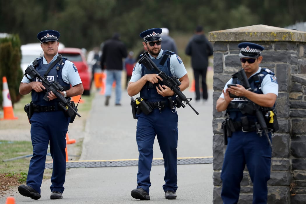Armed police officers stand guard during the burial ceremony of the victims killed in Christchurch's mosque attacks at the Memorial Park Cemetery in Christchurch, New Zealand on March 21, 2019