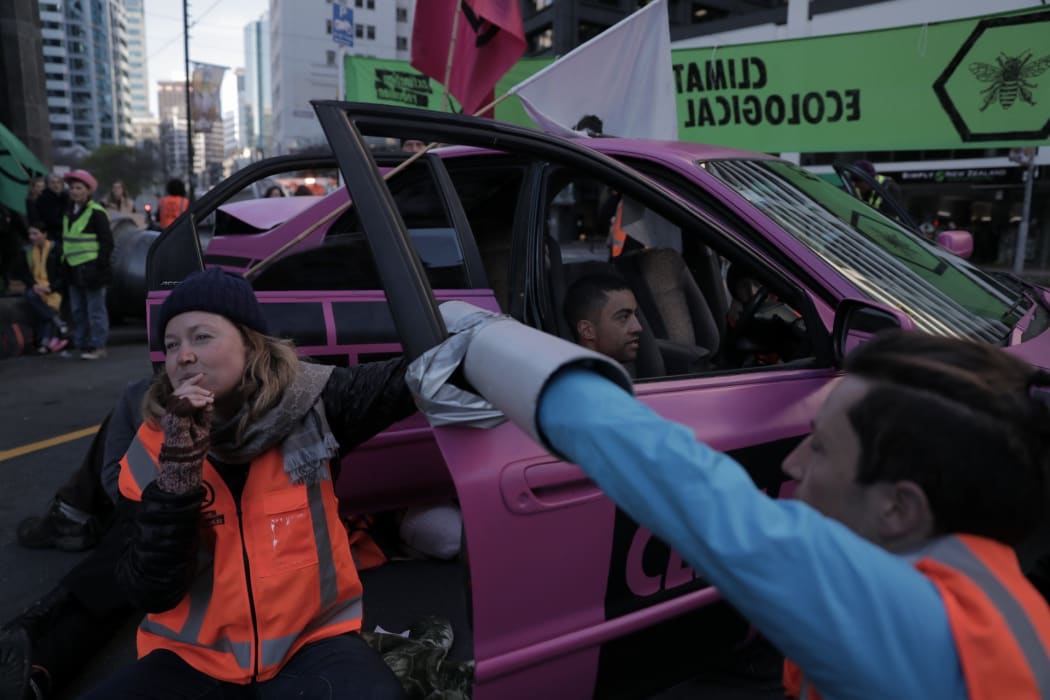 Extinction Rebellion protesters have blocked off Stout St in central Wellington, in a bid to cause disruptions outside MBIE's office.