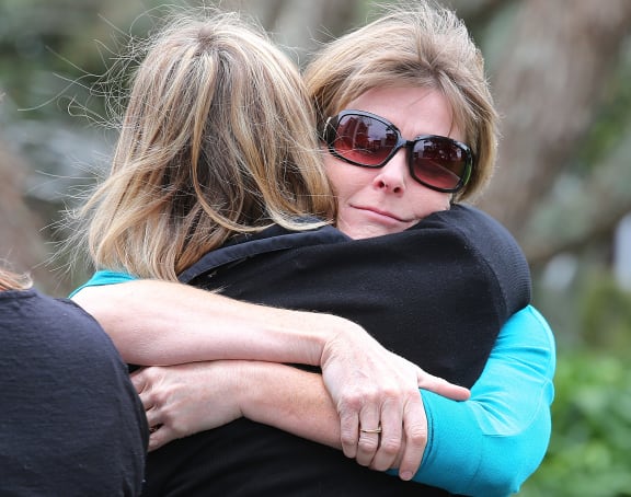 Robyn Jourdain, wife of instructor Bryce Jourdain, is comforted outside the court.