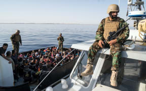 A Libyan coast guardsman watches over during an operation to rescue illegal immigrants who attempted to reach Europe off the coastal town of Zawiyah, 45 kilometres west of the capital Tripoli, on June 27, 2017.