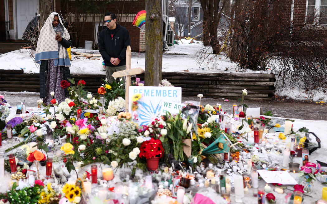 People gather at the street where 37-year-old Renee Nicole Good was shot and killed at point blank range on January 7 by a US Immigration and Customs Enforcement (ICE) agent as she apparently tried to drive away from agents who were crowding around her car, in Minneapolis, Minnesota, on January 8, 2026. A US Immigration and Customs Enforcement (ICE) agent shot and killed an American woman on the streets of Minneapolis January 7, leading to huge protests and outrage from local leaders who rejected White House claims she was a domestic terrorist. The woman, identified in local media as 37-year-old Renee Nicole Good, was hit at point blank range as she apparently tried to drive away from agents who were crowding around her car, which they said was blocking their way. (Photo by CHARLY TRIBALLEAU / AFP)