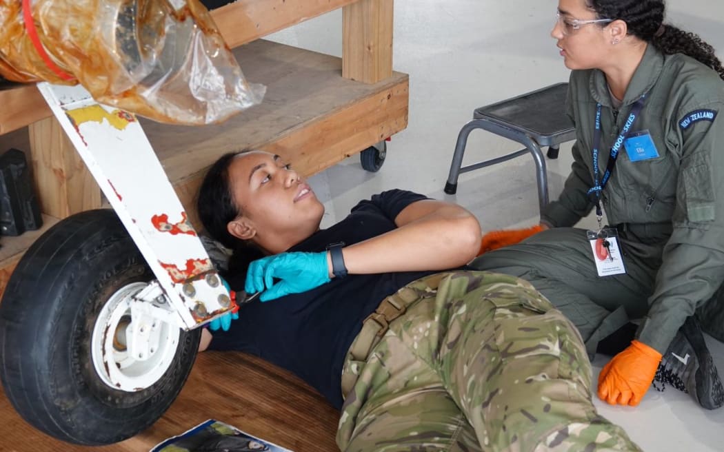 Joanna Maoate instructs a student learning how to attach a wheel to an aircraft.