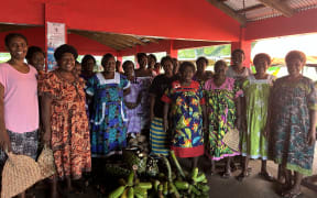 At the Port Vila Show Ground Market, groups of women sold their produce under a marquee-style tarpaulin shelter set up beside a permanent concrete verandah.