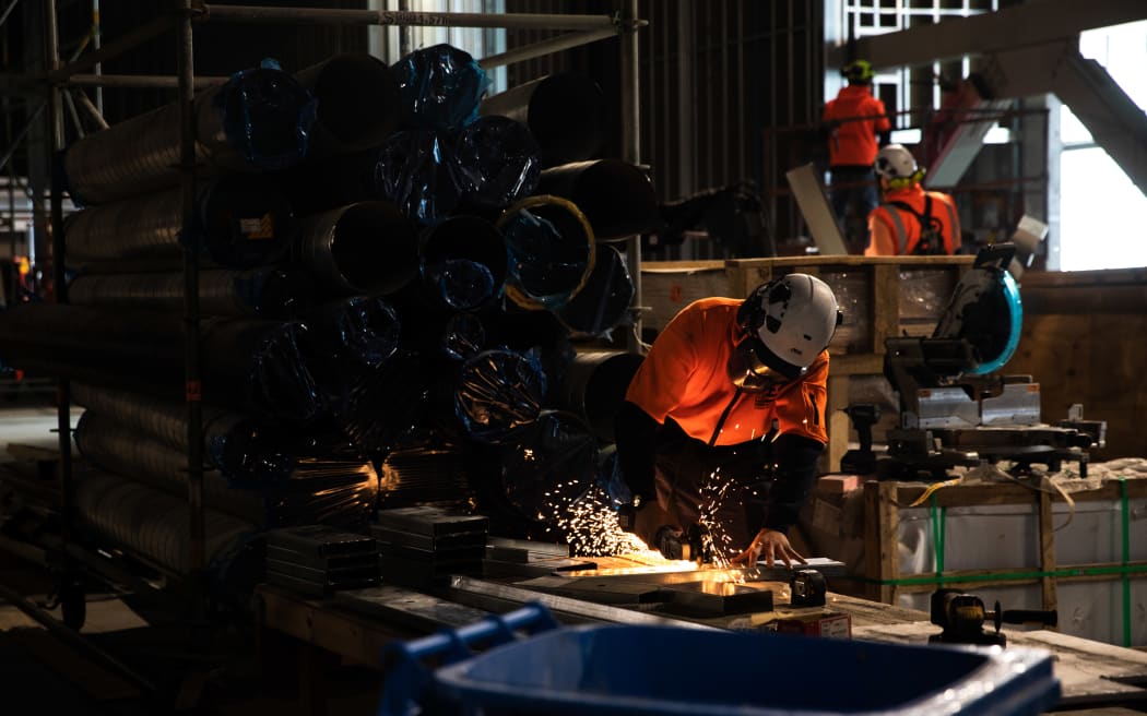 Builder cutting metal at Tākina