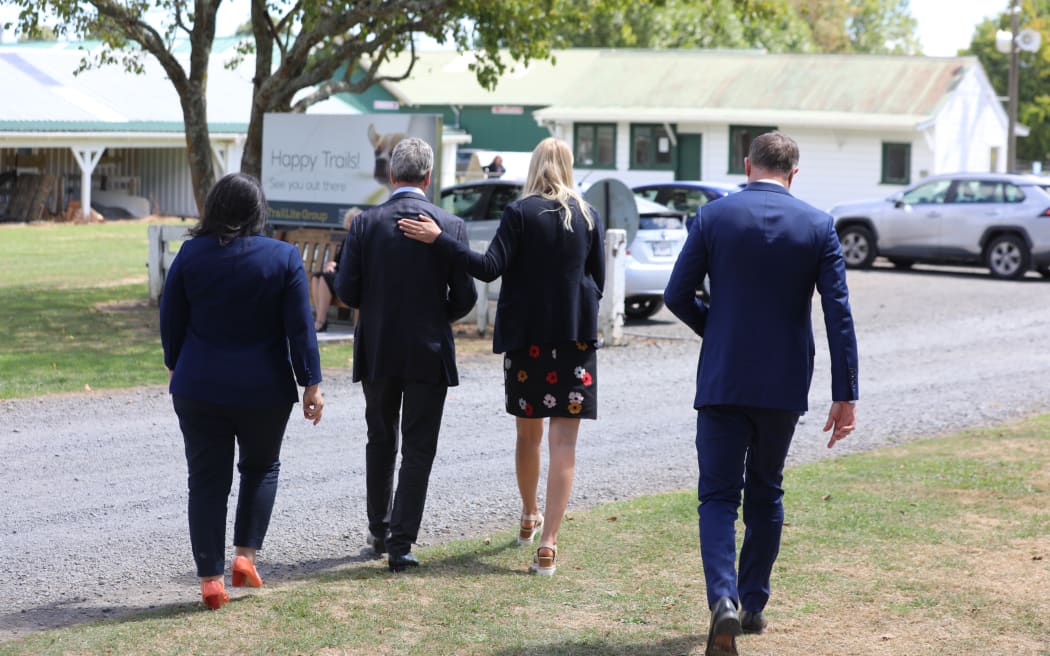 Andrew Bayly walks off as a support staffer rubs his back following talking to media over his resignation from all ministerial positions.