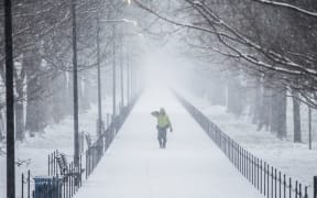 A man walks along the National Mall as the snow begins to fall in Washington, United States.