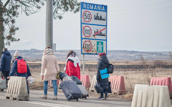 Ukrainian refugees cross the border into Romania.