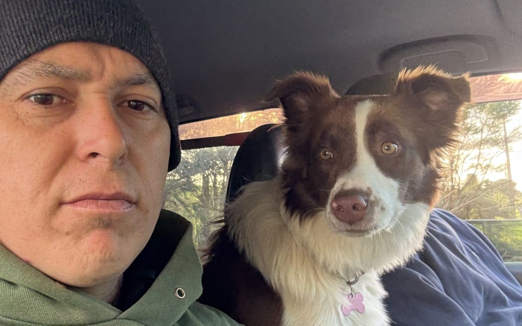 Matt and his missing dog Sadie sitting in the front of his car.