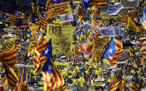 People wave Catalan pro-independence 'estelada' flags during a demonstration to support Catalan pro-independence jailed leaders and politicians and called by 'Espai Democracia i Convivencia' platform that groups separatist collectives and unions in Barcelona on April 15, 2018.