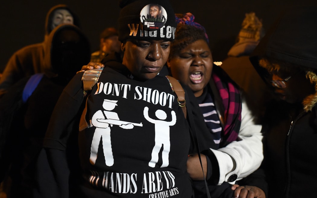 Demonstrators pray in front of the police station in Ferguson, Missouri, ahead of the decision announcement.