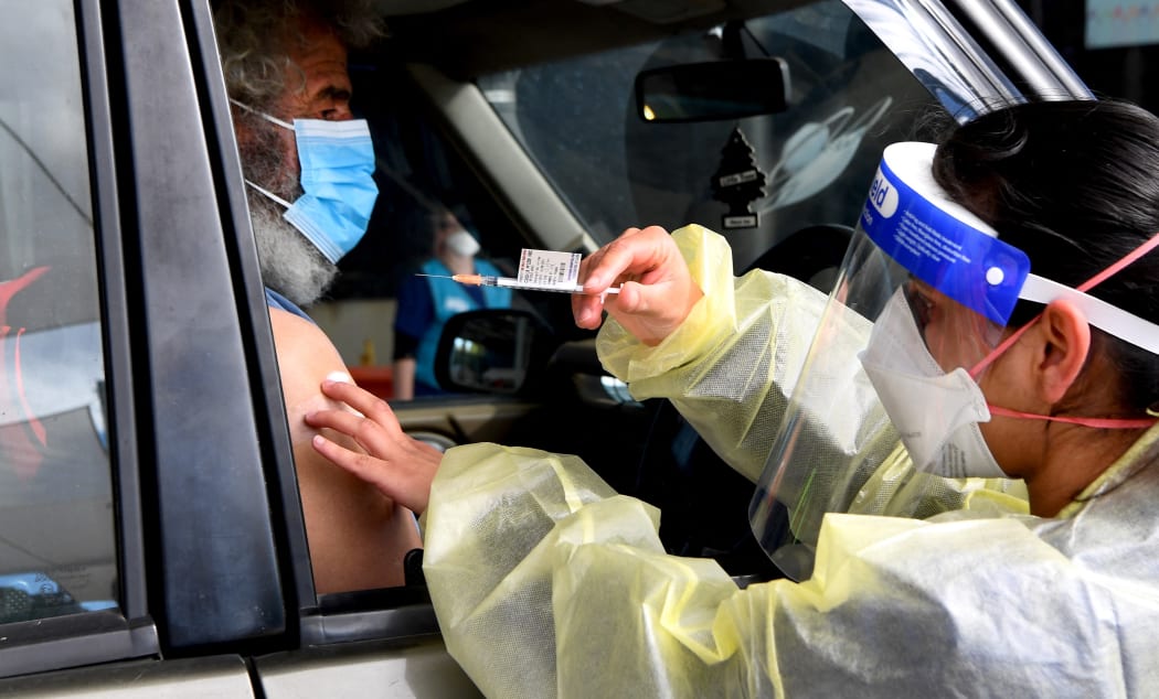 A resident receives a dose of the Pfizer Covid-19 vaccine in Australia's first drive through vaccination centre in the outer Melbourne suburb of Melton on August 10, 2021.