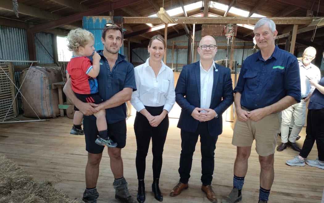 Roscoe (left), with Ollie (2), and Murray Taggart, (far right) hosted Associate Minister Nicola Grigg and Waimakariri MP Matt Doocey for a meeting with farmers in their woolshed at Cust, near Oxford, on Friday.